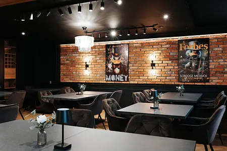 Wnętrze lokalu z ceglaną ścianą i nowoczesnymi meblami w stylu industrialnym.