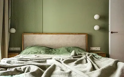 Sypialnia w stylu nowoczesnym i soft minimalizm z zielonymi ścianami i drewnianym łóżkiem.