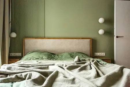 Sypialnia w stylu nowoczesnym i soft minimalizm z zielonymi ścianami i drewnianym łóżkiem.