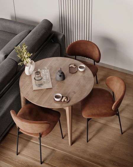 Wnętrze w stylu soft minimalizm z okrągłym stołem i brązowymi krzesłami.