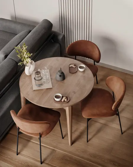Wnętrze w stylu soft minimalizm z okrągłym stołem i brązowymi krzesłami.