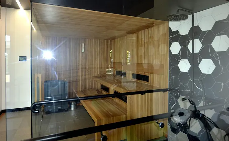 Sauna z drewnem, szklanymi ścianami, nowoczesny i minimalistyczny design.