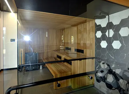 Sauna z drewnem, szklanymi ścianami, nowoczesny i minimalistyczny design.