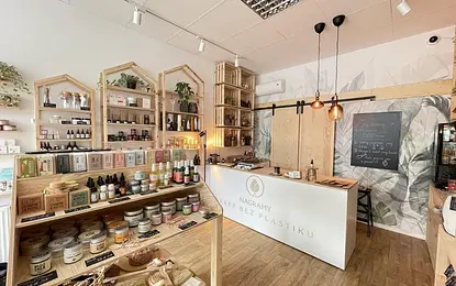 Wnętrze sklepu boho z naturalnymi kosmetykami na drewnianych półkach.