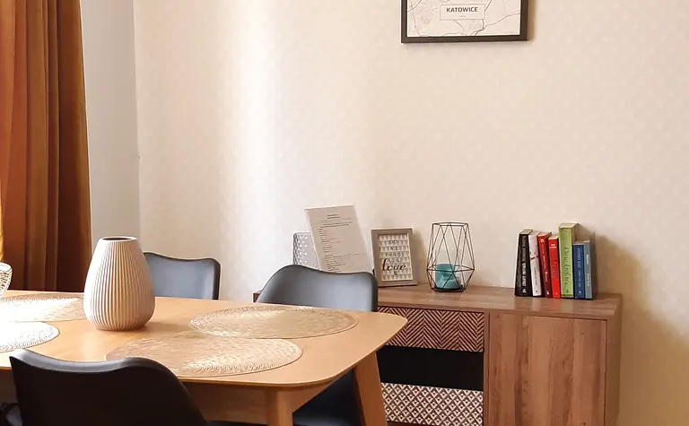 Wnętrze jadalni z drewnianym stołem, czarnymi krzesłami i tradycyjnym wystrojem