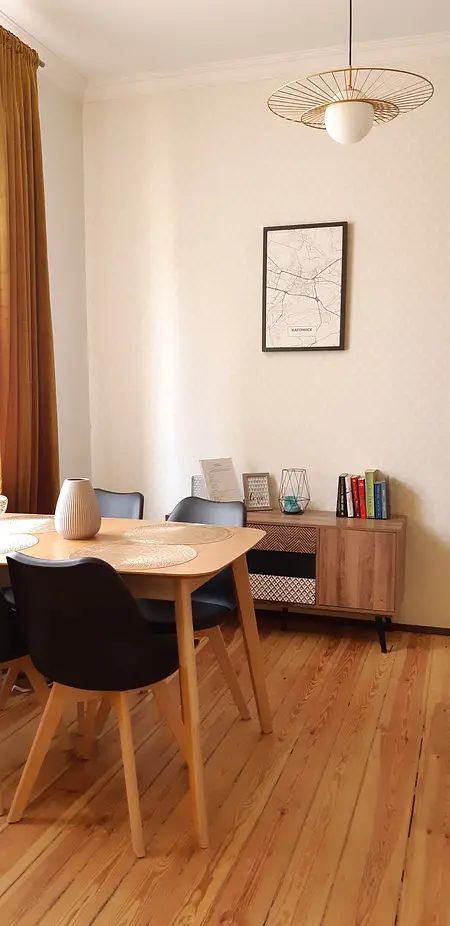 Wnętrze jadalni z drewnianym stołem, czarnymi krzesłami i tradycyjnym wystrojem