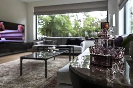 Wnętrze salonu z minimalistycznym designem, meble w stylu minimaluxe i akcenty quiet luxury.