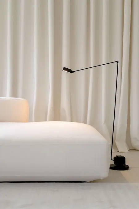Minimalistyczny salon z białą sofą i czarną lampą, wnętrze w stylu minimaluxe.