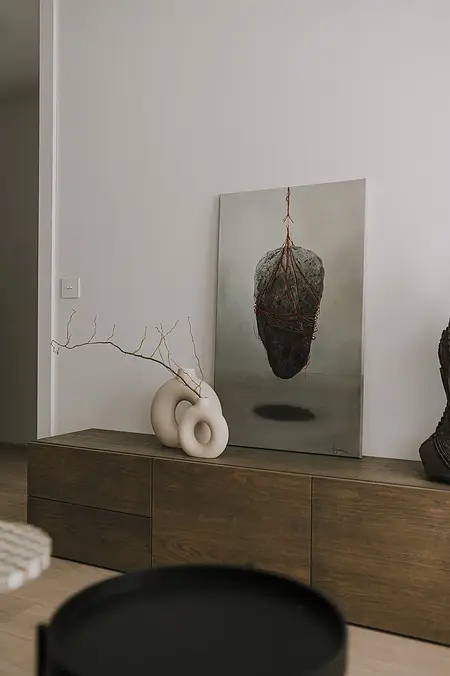 Wnętrze współczesnego salonu z jasnymi meblami i zielenią.