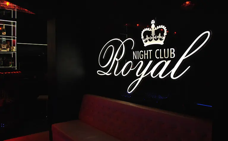 Wnętrze klubu nocnego z podświetleniem LED oraz sofą.