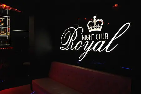 Wnętrze klubu nocnego z podświetleniem LED oraz sofą.