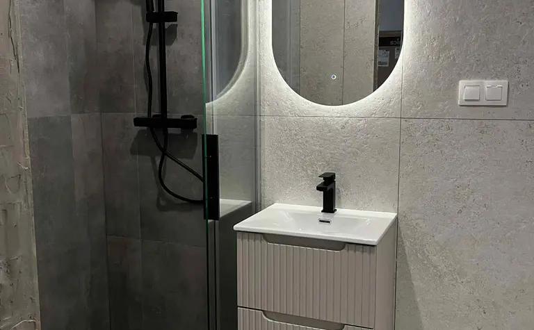 Nowoczesna łazienka z kabiną prysznicową i minimalistycznym umywalką w stylu glamour.