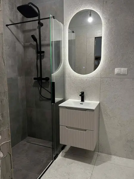Nowoczesna łazienka z kabiną prysznicową i minimalistycznym umywalką w stylu glamour.