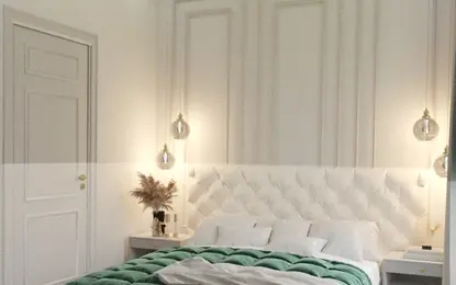 Wnętrze sypialni w stylu glamour z białym łóżkiem i zieloną pościelą, oświetleniem i dekoracjami.