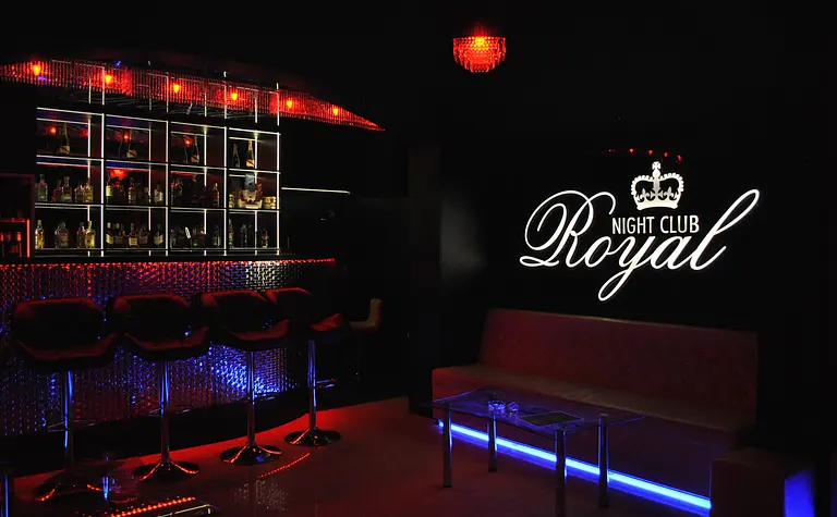 Wnętrze klubu nocnego z ciemnym wystrojem, bar z kolorowym oświetleniem, glamour