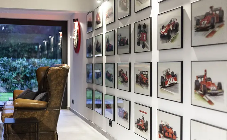 Wnętrze z brązowym fotelem, galerią zdjęć wyścigów, minimalistyczny i quiet luxury.