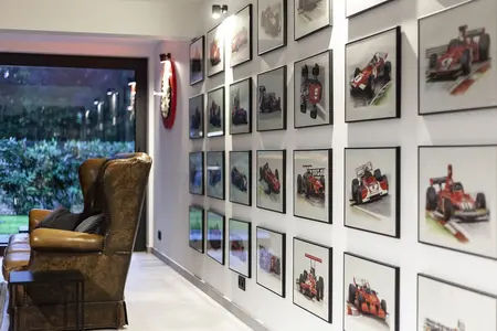 Wnętrze z brązowym fotelem, galerią zdjęć wyścigów, minimalistyczny i quiet luxury.