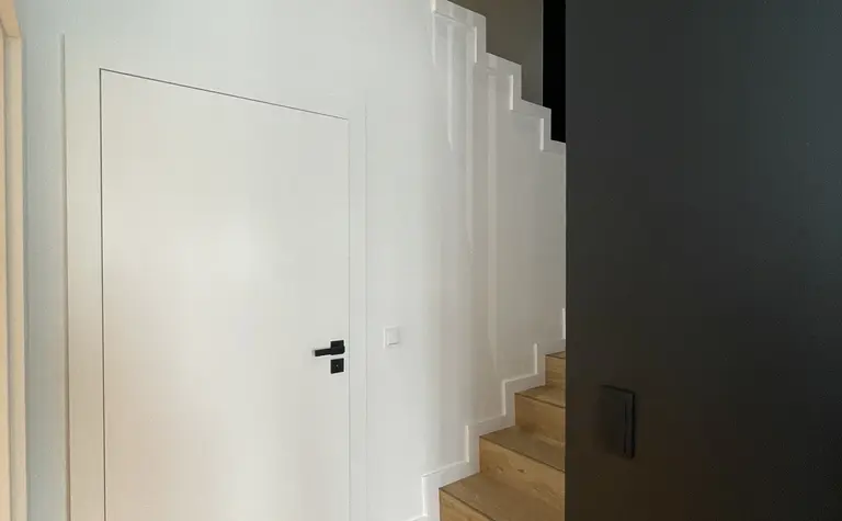 Przedpokój z białymi ścianami, drewnianą podłogą i schodami w stylu eklektycznym i nowoczesnym.