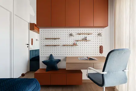 Wnętrze pokoju dziecięcego z brązowymi meblami i niebieskimi dodatkami.