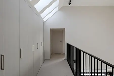 Korytarz z białymi szafkami, szarym podłogą, nowoczesny i współczesny design.