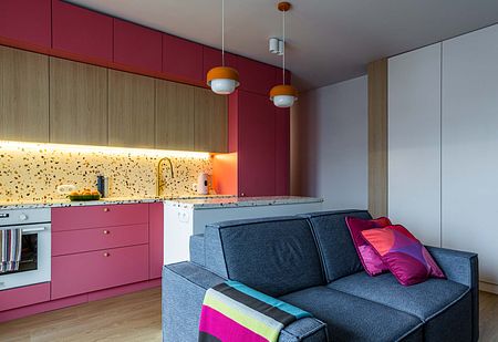 Wnętrze kuchni w stylu dopamine decor i vintage z różowymi meblami.