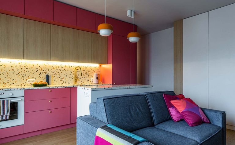 Wnętrze kuchni w stylu dopamine decor i vintage z różowymi meblami.