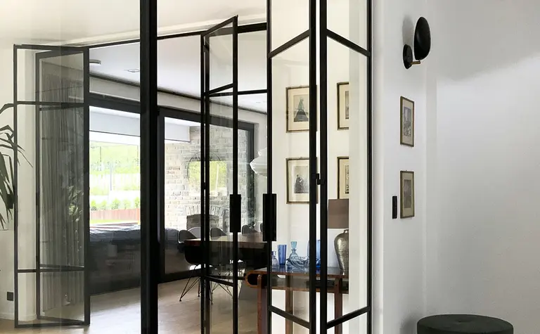 Wnętrze z przeszklonymi drzwiami, minimalistyczne wykończenie, styl minimaluxe, quiet luxury.