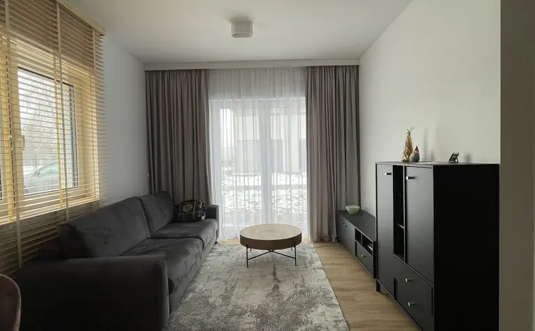 Wnętrze salonu w stylu eklektycznym i nowoczesnym z szarym narożnikiem.