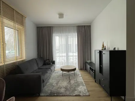 Wnętrze salonu w stylu eklektycznym i nowoczesnym z szarym narożnikiem.