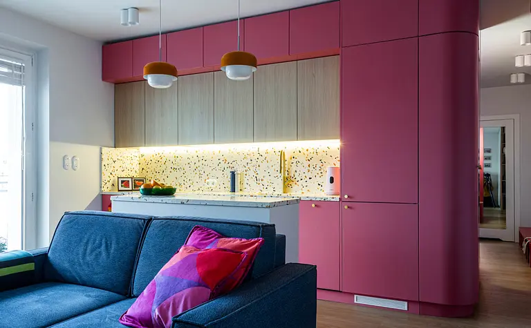 Wnętrze kuchni w stylu dopamine decor i vintage z różowymi meblami.