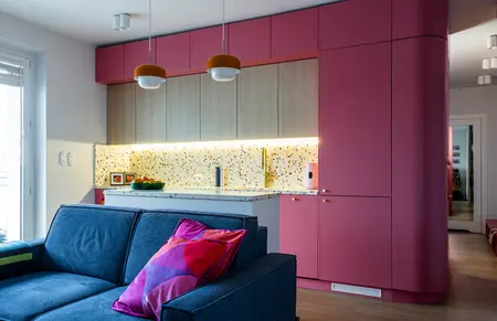 Wnętrze kuchni w stylu dopamine decor i vintage z różowymi meblami.