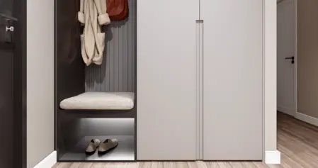 Przedpokój z minimalistycznym designem, w stylu minimaluxe, z szarymi meblami i drewnianą podłogą.
