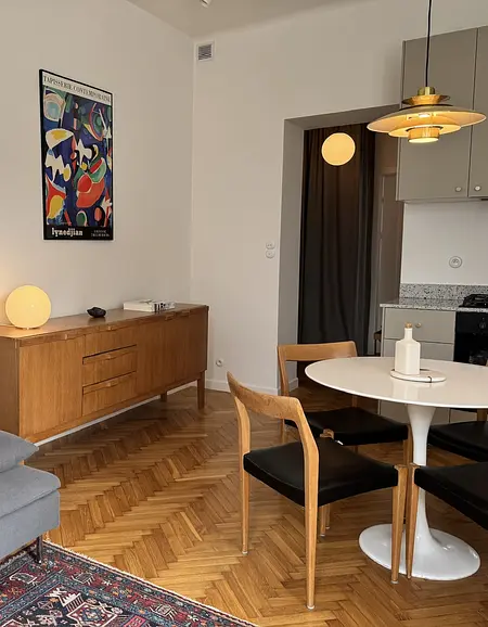 Eklektyczne wnętrze jadalni z drewnianymi akcentami i nowoczesnymi elementami, skandynawski styl.