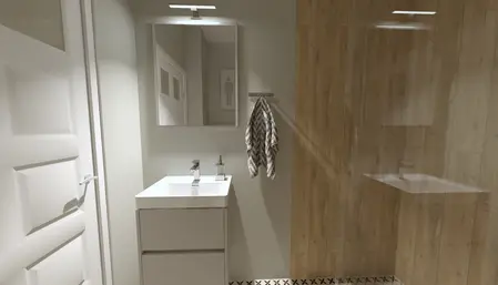 Współczesna łazienka z białą umywalką, lustrem i drewnianymi detalami.