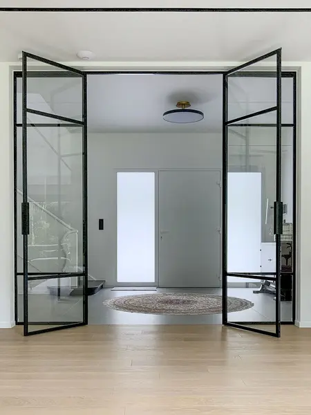 Przestronny przedpokój z przeszklonymi drzwiami, minimalistyczny styl, minimaluxe, quiet luxury.