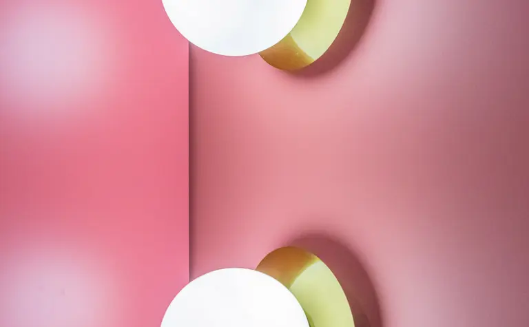 Lampa sufitowa na różowej ścianie w stylu dopamine decor i vintage.