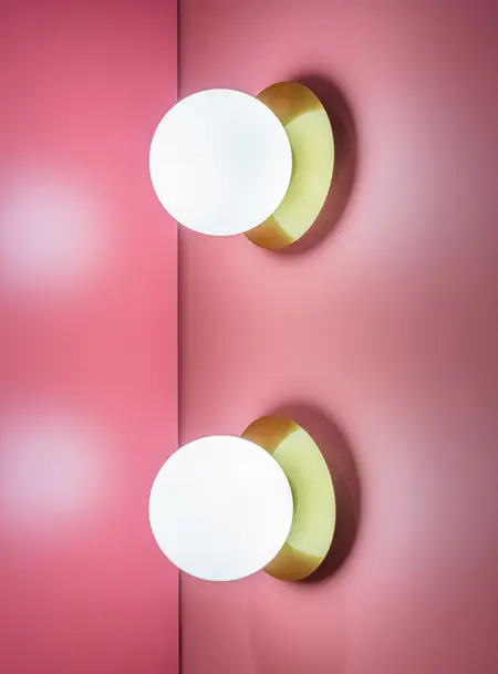 Lampa sufitowa na różowej ścianie w stylu dopamine decor i vintage.