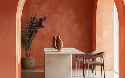 Wnętrze jadalni z białym stołem, pomarańczowymi ścianami i rośliną