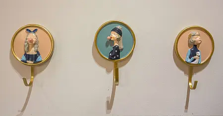 Ściana z wieszakami w stylu dopamine decor i vintage, przedstawiająca postacie.