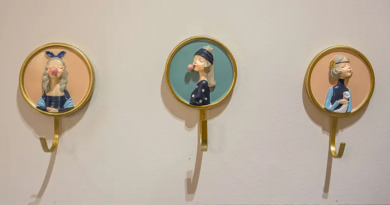 Ściana z wieszakami w stylu dopamine decor i vintage, przedstawiająca postacie.