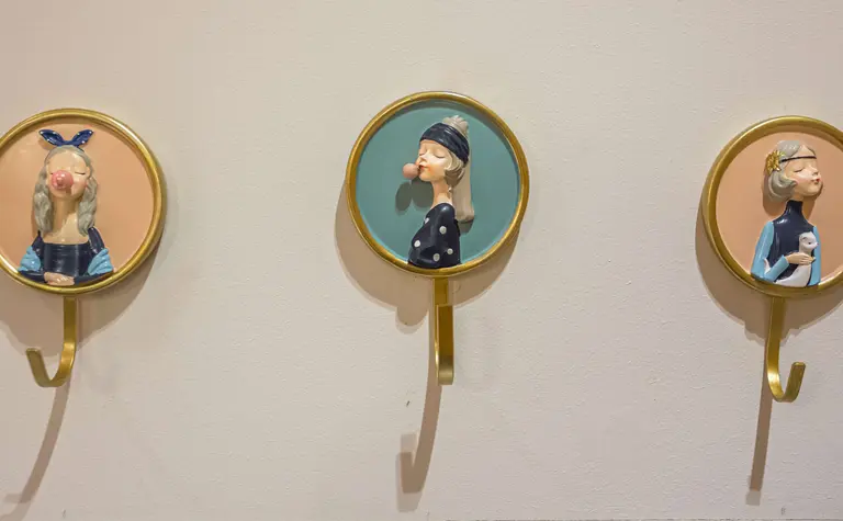 Ściana z wieszakami w stylu dopamine decor i vintage, przedstawiająca postacie.
