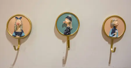 Ściana z wieszakami w stylu dopamine decor i vintage, przedstawiająca postacie.