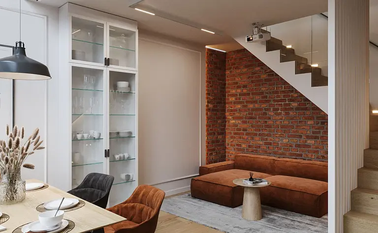 Wnętrze z ceglaną ścianą, brązową sofą i industrialnym stylem