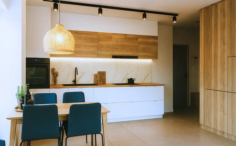 Kuchnia w stylu skandynawskim z drewnianymi meblami i białymi elementami.