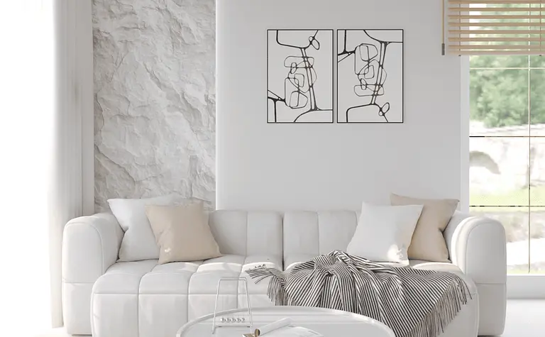 Eklektyczne wnętrze minimalistycznego salonu z białą sofą i skandynawskim dywanem.