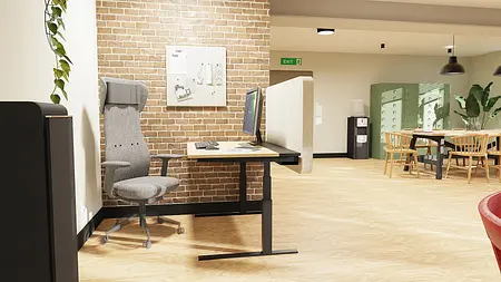 Wnętrze biura z szarym biurkiem, ceglanym murkiem oraz drewnianą podłogą, styl boho i industrialny.