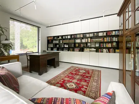 Gabinet w stylu minimalistycznym z regałem i biurkiem, styl minimaluxe i quiet luxury.