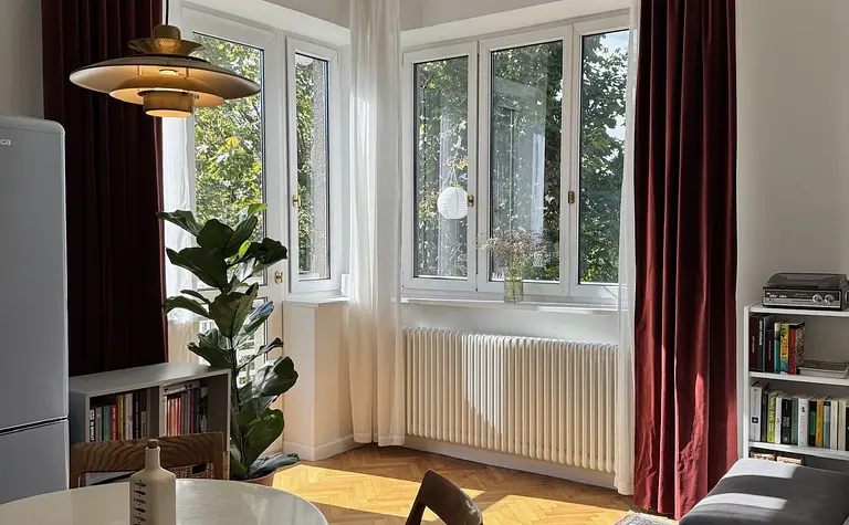 Eklektyczne wnętrze salonu ze skandynawskim akcentem i vintage meblami.