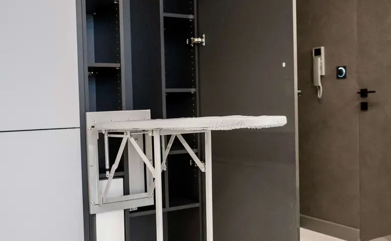 Nowoczesne wnętrze z szarymi meblami i składanym stołem, idealne do małych przestrzeni.