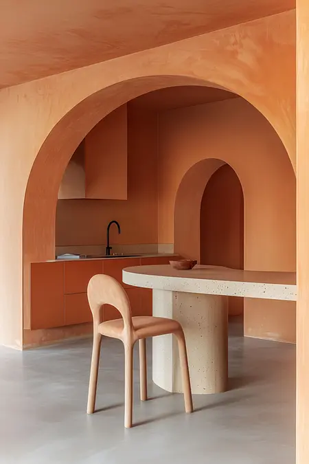 Wnętrze kuchni z pomarańczowymi ścianami i nowoczesnym blatem.